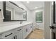 Bright bathroom featuring a large mirror, quartz countertops, modern fixtures, and wood-look flooring at 4645 Quail Run Dr, New Palestine, IN 46163