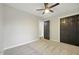 Bedroom featuring closet space with dark wooden doors, plush carpet, a modern ceiling fan, and neutral walls at 4645 Quail Run Dr, New Palestine, IN 46163