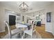 Bright dining area with modern light fixture and a view into the renovated kitchen with a breakfast bar at 4645 Quail Run Dr, New Palestine, IN 46163