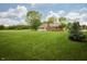 Expansive backyard featuring a lush lawn, mature trees, and a covered porch at 4901 E County Road 100 N, Avon, IN 46123