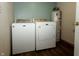 A bright laundry room featuring a modern washer and dryer set and a water heater at 4901 E County Road 100 N, Avon, IN 46123