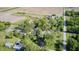 This aerial view showcases a lush, tree-lined property with a quaint farmhouse and agricultural buildings at 496 N County Road 325 W, Danville, IN 46122