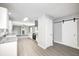 Open concept kitchen with stainless steel appliances, granite counters, and a sliding barn door at 496 N County Road 325 W, Danville, IN 46122