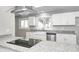 Bright kitchen with white cabinets, granite counters, a farmhouse sink, and modern appliances at 496 N County Road 325 W, Danville, IN 46122