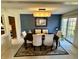 Formal dining room with a dark wood table, upholstered chairs, stylish light fixture, and sliding glass door at 5491 Vin Rose Ln, Lawrence, IN 46226