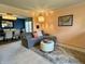 A stylish living room featuring a comfortable gray sofa, ottoman, and an adjacent dining area at 5491 Vin Rose Ln, Lawrence, IN 46226