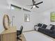 Bright bedroom featuring a ceiling fan, desk with decor, and comfy black couch at 5570 Paradise Ct, Martinsville, IN 46151