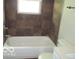 Tiled bathroom with a bathtub and shower combo, accented by stone-look accent tiles at 620 S 2Nd St, Noblesville, IN 46060