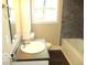 This well-lit bathroom features gray tiled walls and a white sink and bath, creating a clean and modern space at 620 S 2Nd St, Noblesville, IN 46060