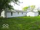 This single-story home with light siding features a matching detached garage and green backyard at 620 S 2Nd St, Noblesville, IN 46060