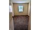 A bedroom with neutral-colored walls, brown carpet, and a window providing natural light at 6322 Commons Dr, Indianapolis, IN 46254