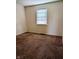 A bedroom with neutral-colored walls, brown carpet, and a window providing natural light at 6322 Commons Dr, Indianapolis, IN 46254