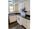 Traditional-style kitchen with white appliances, dark countertops and wood-look flooring at 6322 Commons Dr, Indianapolis, IN 46254