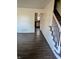 Hallway with staircase, light walls, and wood-look flooring at 6322 Commons Dr, Indianapolis, IN 46254