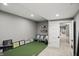 Bright basement with artificial turf, a small couch, and a white door at 6882 Bladstone Rd, Noblesville, IN 46062