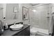 Modern bathroom featuring a walk in shower, dark vanity with granite countertops, and neutral colored walls at 6882 Bladstone Rd, Noblesville, IN 46062