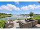 Backyard patio with elegant seating and fire pit overlooking the scenic lake at 6882 Bladstone Rd, Noblesville, IN 46062