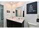 Bathroom vanity with double sinks, stylish fixtures, and a framed mirror that is flanked by decorative wall art at 6883 Honeysuckle Way, Pendleton, IN 46064
