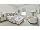 Cozy bedroom with neutral tones, featuring a bed with a bench, bedside table, and armchair at 6883 Honeysuckle Way, Pendleton, IN 46064