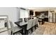 Open concept dining area with a dark wood table, six chairs and stainless steel kitchen appliances at 6883 Honeysuckle Way, Pendleton, IN 46064