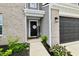 Home's front door with brick and siding, a 'Welcome' sign, and dark gray garage door at 6883 Honeysuckle Way, Pendleton, IN 46064