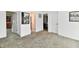 Bright hallway featuring neutral walls and carpet, multiple doorways, and decorative artwork at 6883 Honeysuckle Way, Pendleton, IN 46064