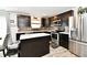 Modern kitchen with stainless steel appliances, dark wood cabinets, and island with a white countertop at 6883 Honeysuckle Way, Pendleton, IN 46064