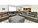 Open-concept living room with a sectional sofa, ottoman, and views of the kitchen at 6883 Honeysuckle Way, Pendleton, IN 46064