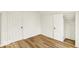 Bright bedroom featuring modern laminate floors, fresh white paint, and convenient closet space at 701 E Memorial Dr, Muncie, IN 47302