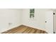 Bedroom featuring laminate floors, white walls, trim, and a view to the outside at 701 E Memorial Dr, Muncie, IN 47302