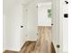 Bright hallway with wood floors leads to bedroom and bathroom at 701 E Memorial Dr, Muncie, IN 47302