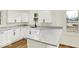 Bright kitchen features white cabinetry, granite countertops, stainless steel sink, and wood-look flooring at 701 E Memorial Dr, Muncie, IN 47302