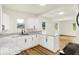 Bright kitchen features white cabinetry, granite countertops, stainless steel sink, and wood-look flooring at 701 E Memorial Dr, Muncie, IN 47302