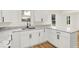 Bright kitchen features white cabinetry, granite countertops, stainless steel sink, and wood-look flooring at 701 E Memorial Dr, Muncie, IN 47302