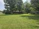 Large backyard showcasing a well-maintained lawn and mature trees, perfect for outdoor activities at 7088 Sandalwood Dr, Indianapolis, IN 46217