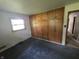 Cozy bedroom with carpet and large built-in wood wardrobe storage with a window at 7088 Sandalwood Dr, Indianapolis, IN 46217