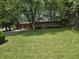 Traditional brick home featuring an attached two-car garage and a well-manicured lawn with mature trees at 7088 Sandalwood Dr, Indianapolis, IN 46217