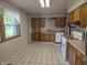 Bright kitchen with checkered floors, wood cabinets, and modern white appliances at 7088 Sandalwood Dr, Indianapolis, IN 46217