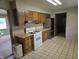 Kitchen features wood cabinets, gas range, and a view into the living room at 7088 Sandalwood Dr, Indianapolis, IN 46217