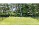 Private backyard with manicured lawn and mature trees, enclosed by a fence, offering a tranquil and secluded retreat at 7154 Covington St, Lebanon, IN 46052