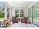Cozy sunroom filled with natural light from large windows, furnished with comfortable chairs and a view of the backyard at 7154 Covington St, Lebanon, IN 46052