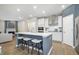 Island seating in a modern kitchen, opening to an adjacent living space with a fireplace and seating at 7177 Firestone Rd, Whitestown, IN 46052