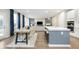 Open concept view of a kitchen, dining, and living space, featuring hardwood floors and lots of natural light at 7177 Firestone Rd, Whitestown, IN 46052