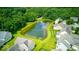 Overhead view of a neighborhood surrounding a pond, surrounded by lush trees at 7212 Maple Bluff Pl, Indianapolis, IN 46236