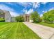Inviting brick home with an attached garage and mature trees in a beautifully landscaped front yard and long driveway at 7212 Maple Bluff Pl, Indianapolis, IN 46236