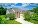 Well-maintained two-story brick home with attached two-car garage and beautifully landscaped front yard at 7212 Maple Bluff Pl, Indianapolis, IN 46236