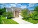 Inviting brick home with a spacious driveway, attached garage, and lush green trees in the front yard at 7212 Maple Bluff Pl, Indianapolis, IN 46236