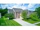 Attractive brick home featuring a two-car garage, manicured lawn, and a beautifully landscaped front yard at 7212 Maple Bluff Pl, Indianapolis, IN 46236