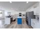 Modern kitchen boasts white cabinets, stainless steel appliances, a central island, and wood-look flooring at 7212 Maple Bluff Pl, Indianapolis, IN 46236