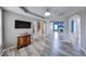 Inviting living room featuring hardwood floors, an elegant cabinet, and seamless flow to other living spaces at 7212 Maple Bluff Pl, Indianapolis, IN 46236